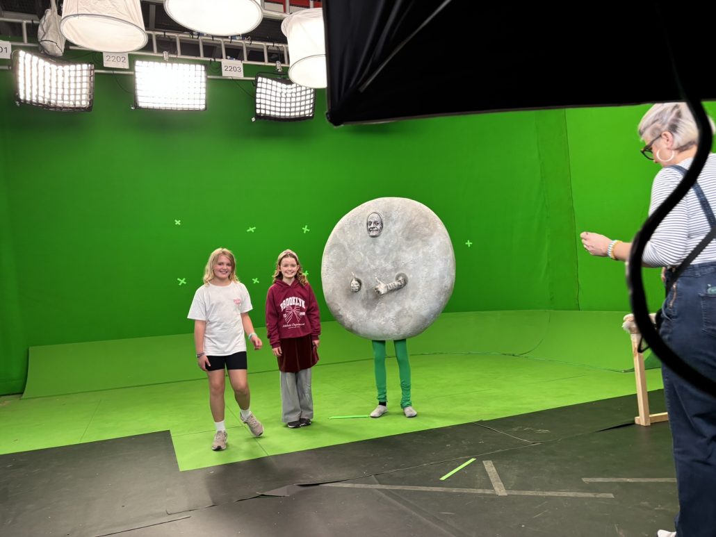 Luke Rollason dressed as the Moon in front of a green screen during filming of Horrible Science
