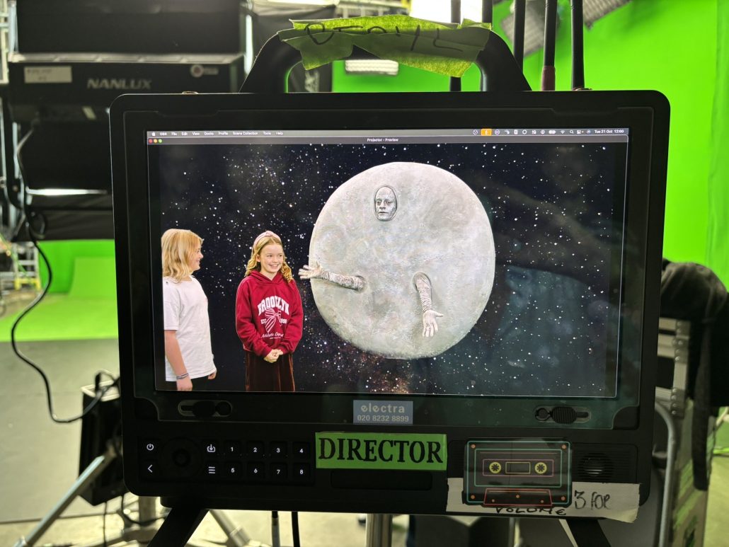 The Moon character on set with the space background added using green screen effects in Horrible Science