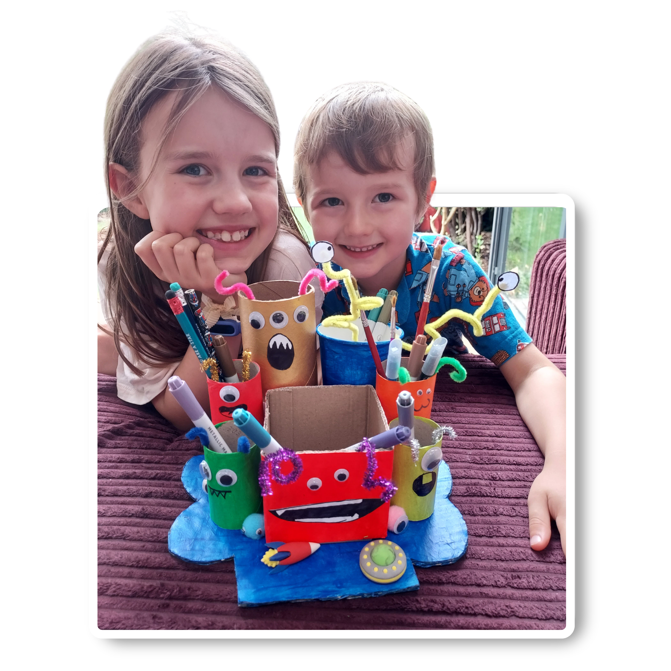 Two children smiling with homemade desk organiser